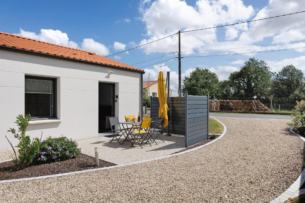 a patio with a table and chairs and a building at Gite Logeraie in Le Boupère