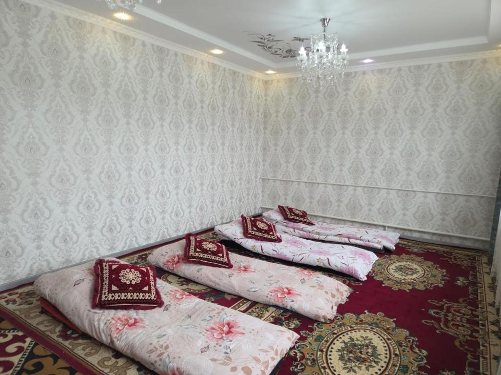 a bedroom with three beds in a room with wallpaper at Dosoi Guest House Experience Song-Kul with Horseback Tours in Kyzylemgek