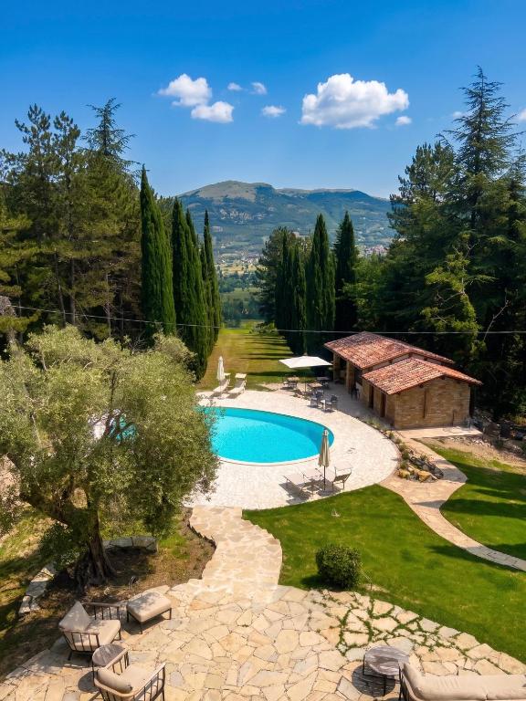 a pool in a yard with chairs and a building at Residenza Castelnovo in Gubbio