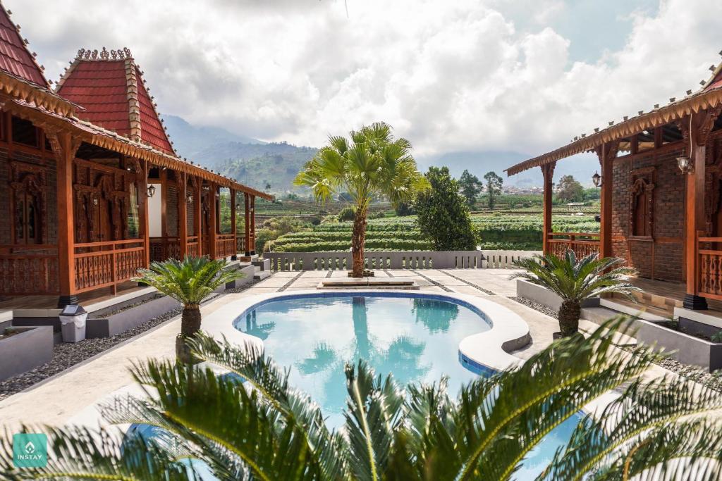 an image of a house with a swimming pool in the yard at Instay Villa Dieng Kademangan in Wonosobo