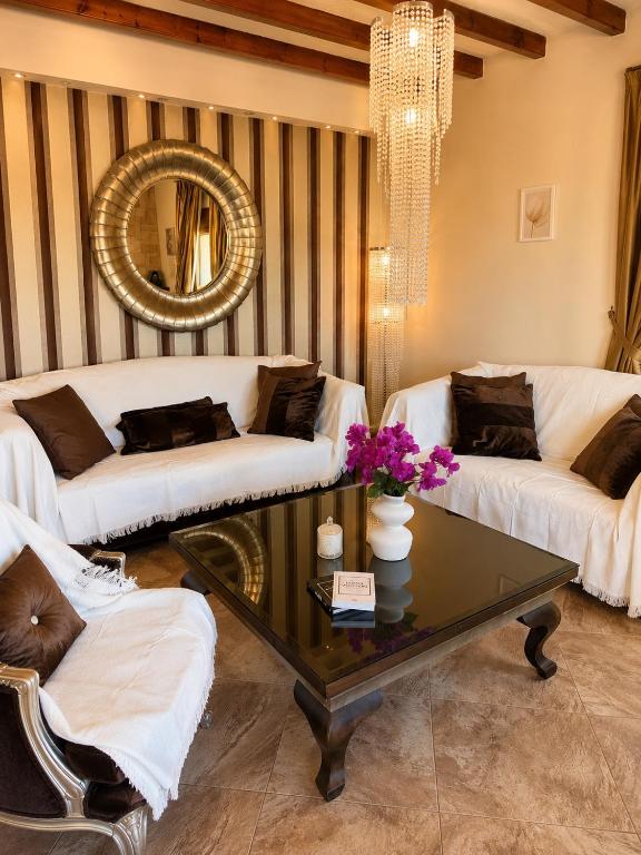 a living room with two white couches and a table at Marsia House in Vathí