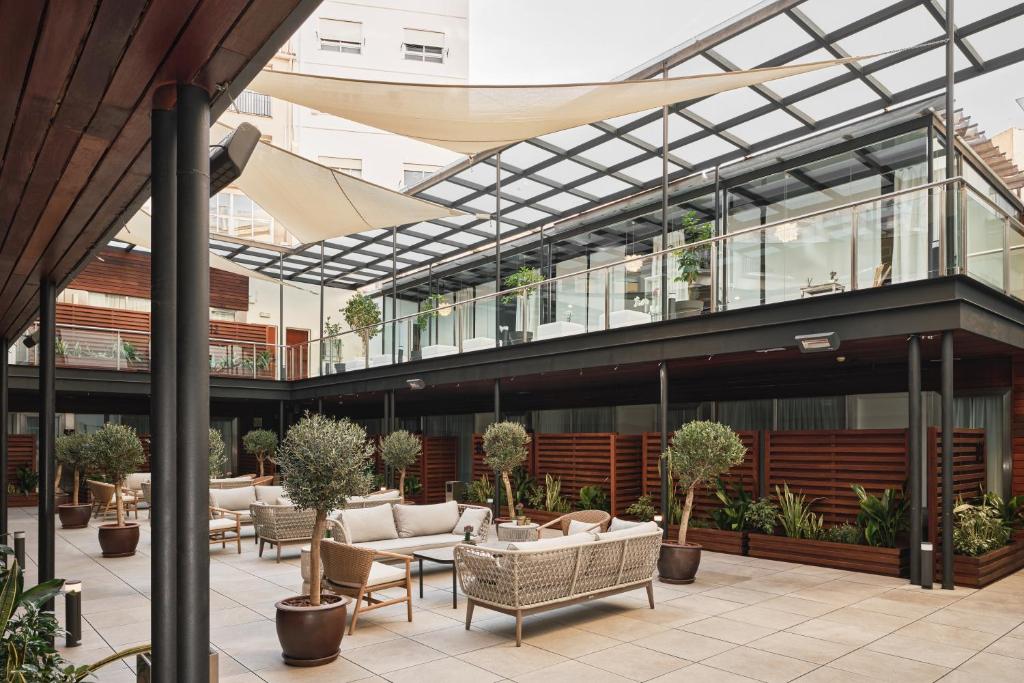 a building with a patio with chairs and tables at Hospes Palau de La Mar, Valencia, a Member of Design Hotels in Valencia