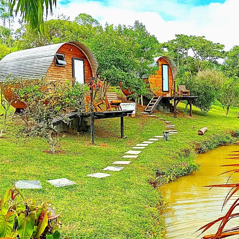 a couple of huts are next to a stream at Sitio casa di vó in Rio Forcação