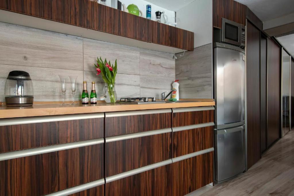 a kitchen with wooden cabinets and a stainless steel refrigerator at Apartman Borievka in Poprad