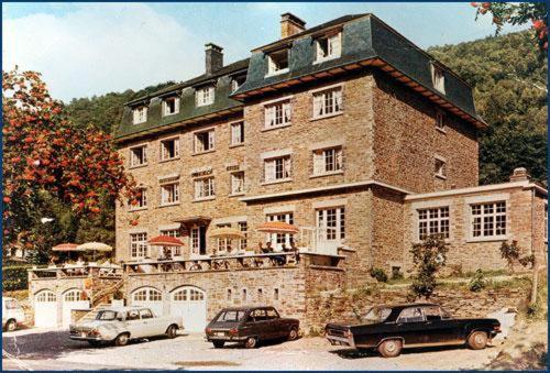 duży ceglany budynek z samochodami zaparkowanymi przed nim w obiekcie Hotel Fief De Liboichant w Alle