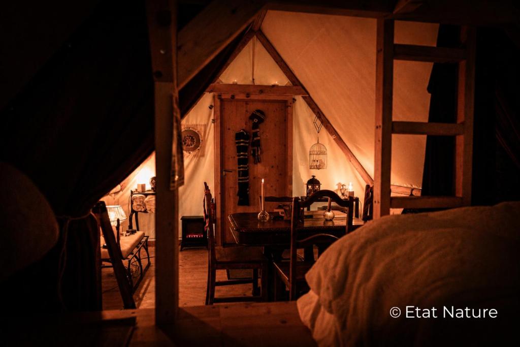 a room with a dining table in a tent at Gîte du sorcier - Etat Nature in Magnières