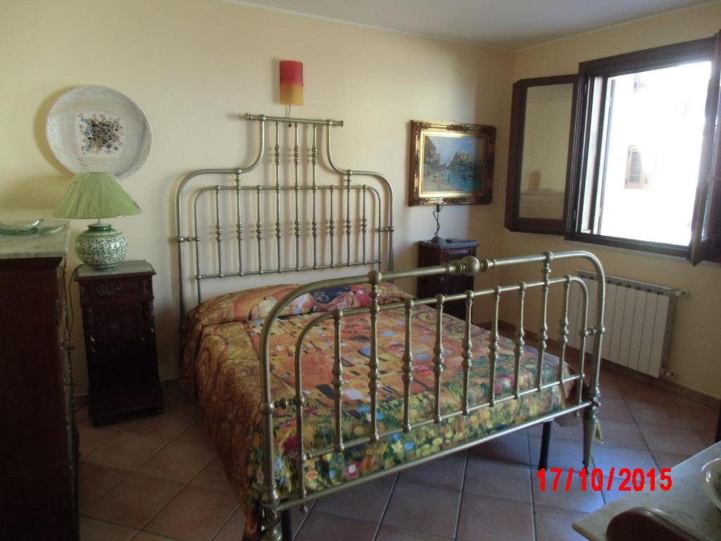 ポルティチェッロにあるHoliday home Santa Flavia 2のベッドルーム1室(ベッド1台、ランプ、窓付)