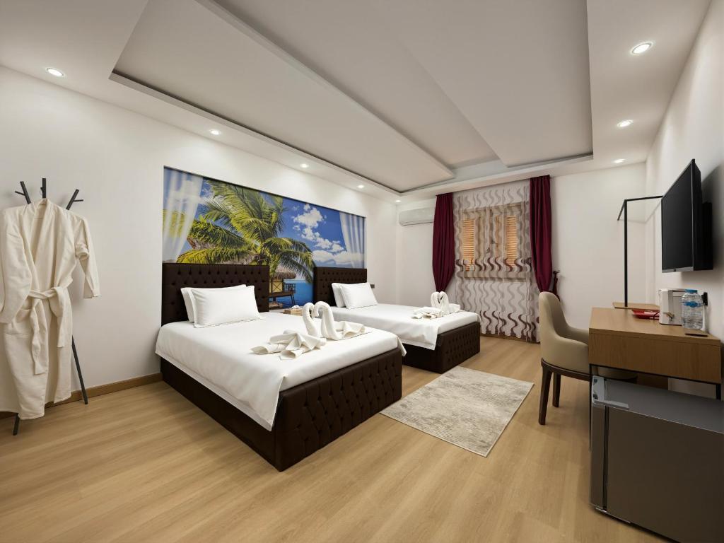 a hotel room with two beds and a desk at JubingeHotel 聚滨阁华人酒店 in Cairo