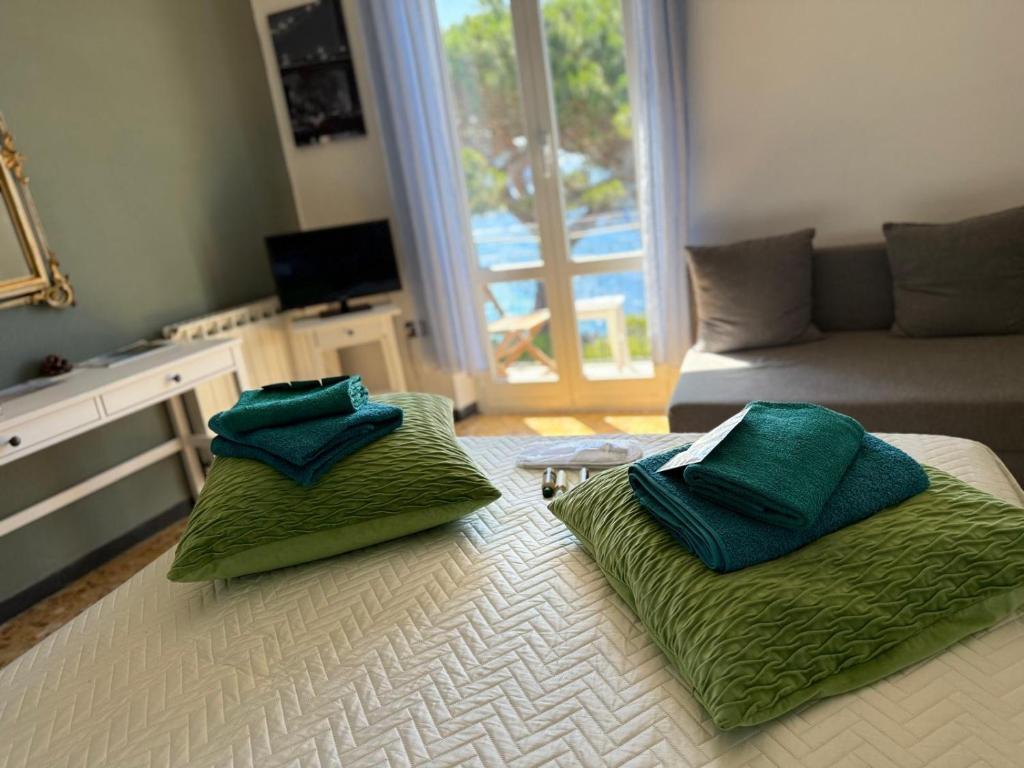 two green pillows sitting on a bed in a living room at Appartamento giumin in Corniglia