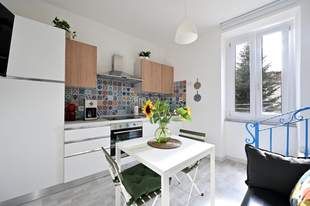 a kitchen with a white table with a vase of flowers at Little Cozy House in Loro Ciuffenna