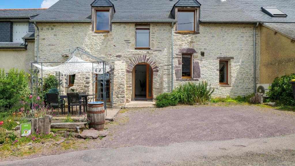 a stone house with a driveway in front of it at Gîte La Longère in Laillé