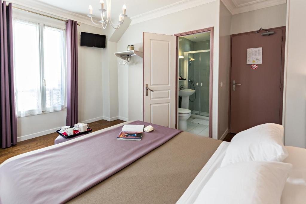 a large bed in a room with a bathroom at Modern Hotel in Paris