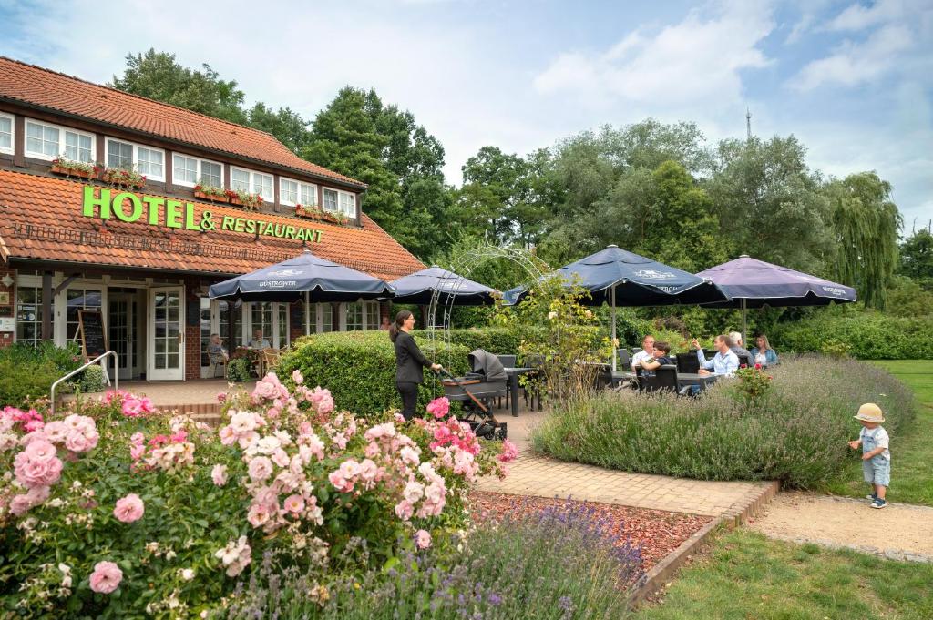 a group of people sitting at a hotel with a garden at Hotel und Restaurant Röbler Thor in Wittstock