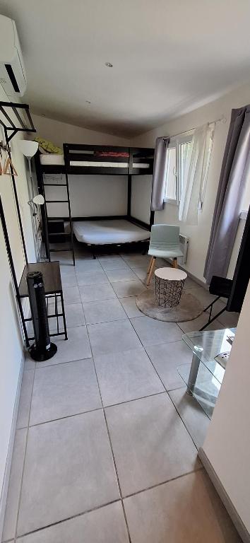 a room with a tiled floor with a room with bunk beds at Maisonette bedogao in Valence