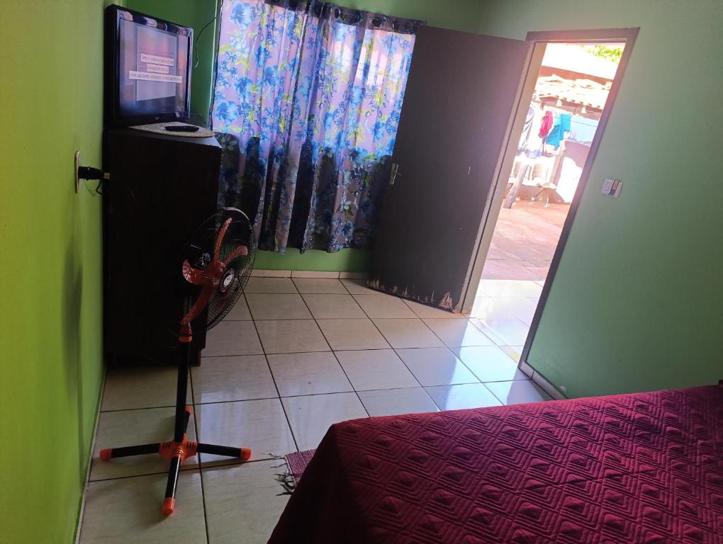 a room with a room with a bed and a television at cantinho do descanso in Dourados