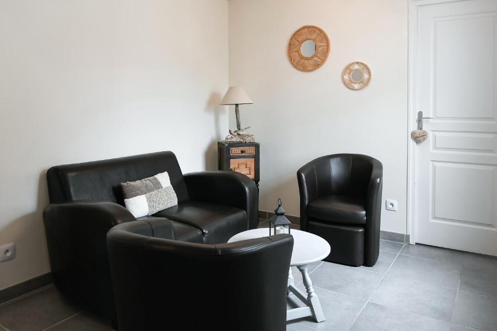 a living room with two chairs and a table at Gîte Maison de pêcheur in Le Crotoy