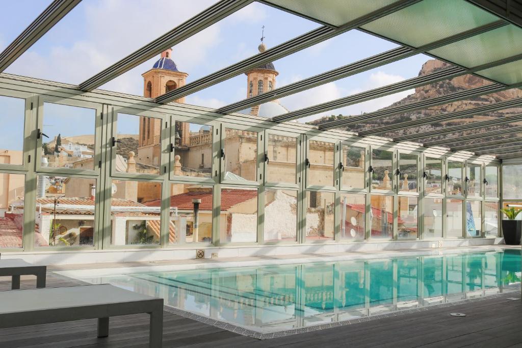 a large pool in a building with glass walls at Hospes Amérigo, Alicante, a Member of Design Hotels in Alicante