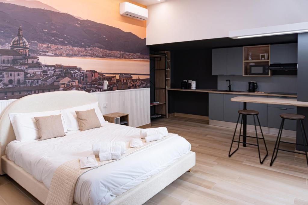 a bedroom with a white bed and a kitchen at Salerno Stay in Salerno