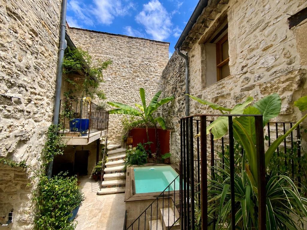 a courtyard with a swimming pool in a building at La grange in Aspères