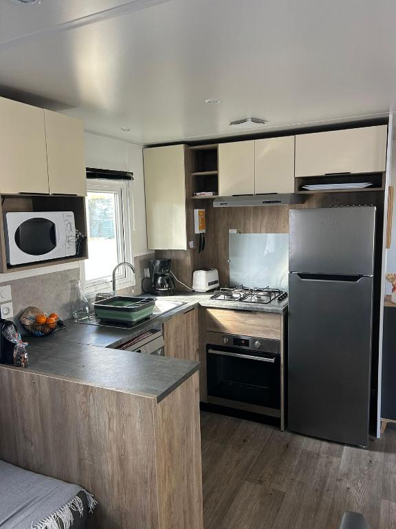 a kitchen with a refrigerator and a stove top oven at Camping du CONGUEL in Quiberon