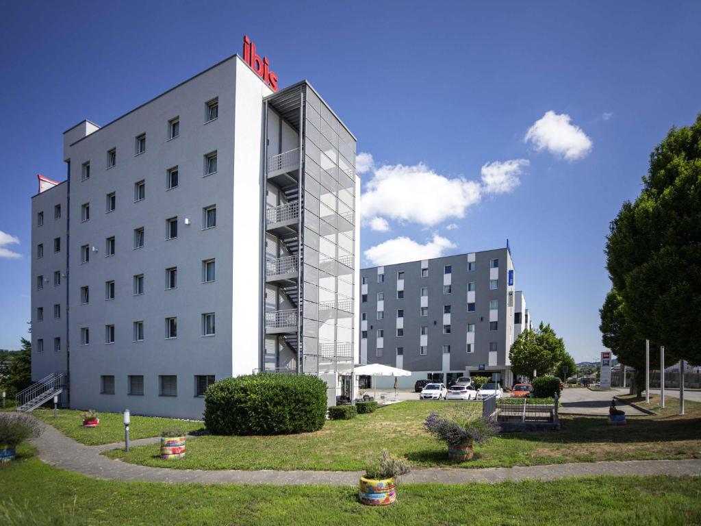 a white building with a sign on top of it at ibis Fribourg in Fribourg