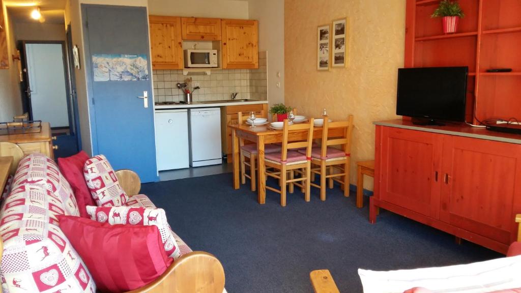 a living room with a couch and a table and a kitchen at Le Tyrol in Les Deux Alpes