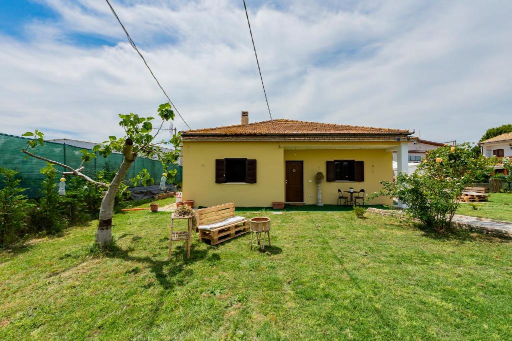 a small yellow house with a table and chairs in a yard at GuestHost - Barni House in Montesilvano