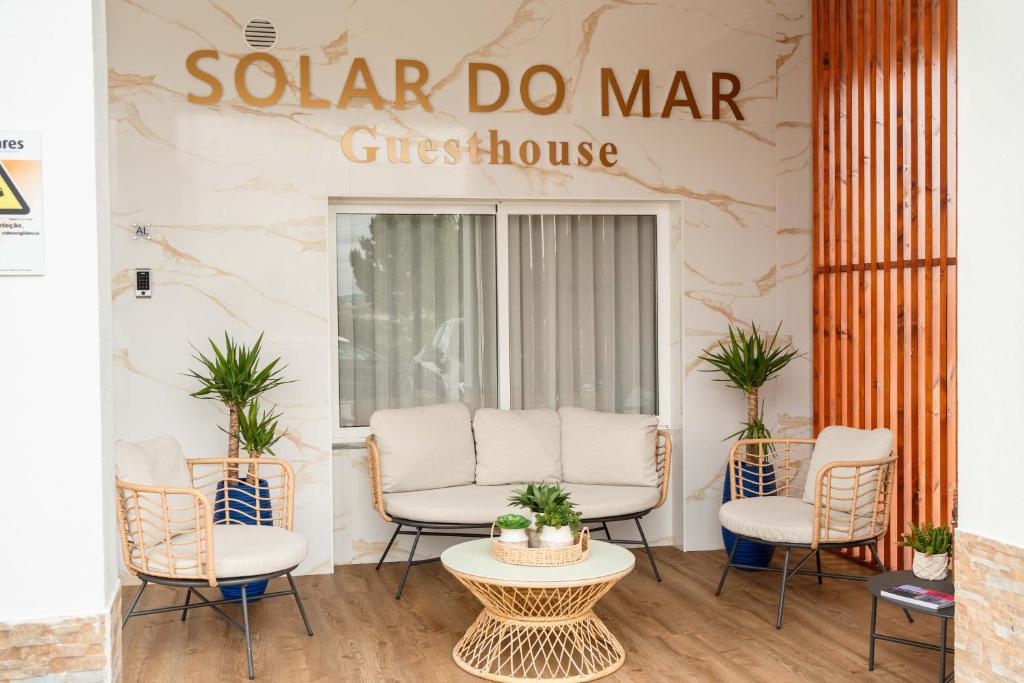 a sign for a spa do mar guest house with chairs and a table at Guesthouse Solar do Mar in Silveira