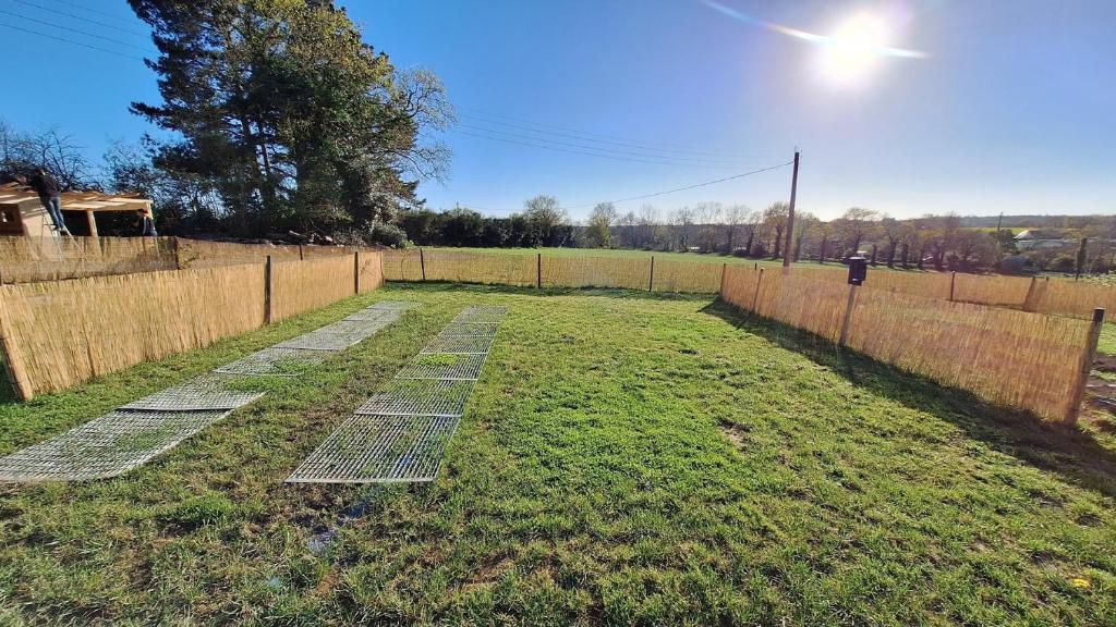 a garden with a fence and a field at Camping La Ferme du Guéric in Riec-sur-Bélon