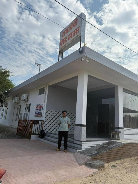 a man standing in the doorway of a building at RADHA DEVI GUEST HOUSe in Juliāsar