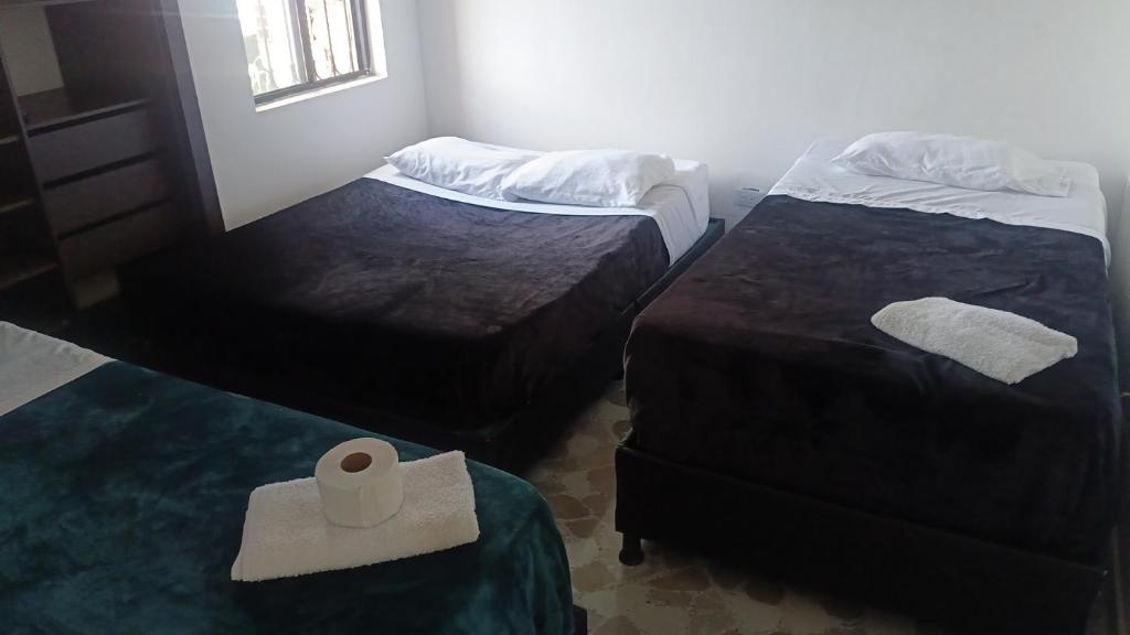 a room with two beds and a roll of toilet paper at Hotel campestre terrazas y sol in La Vega