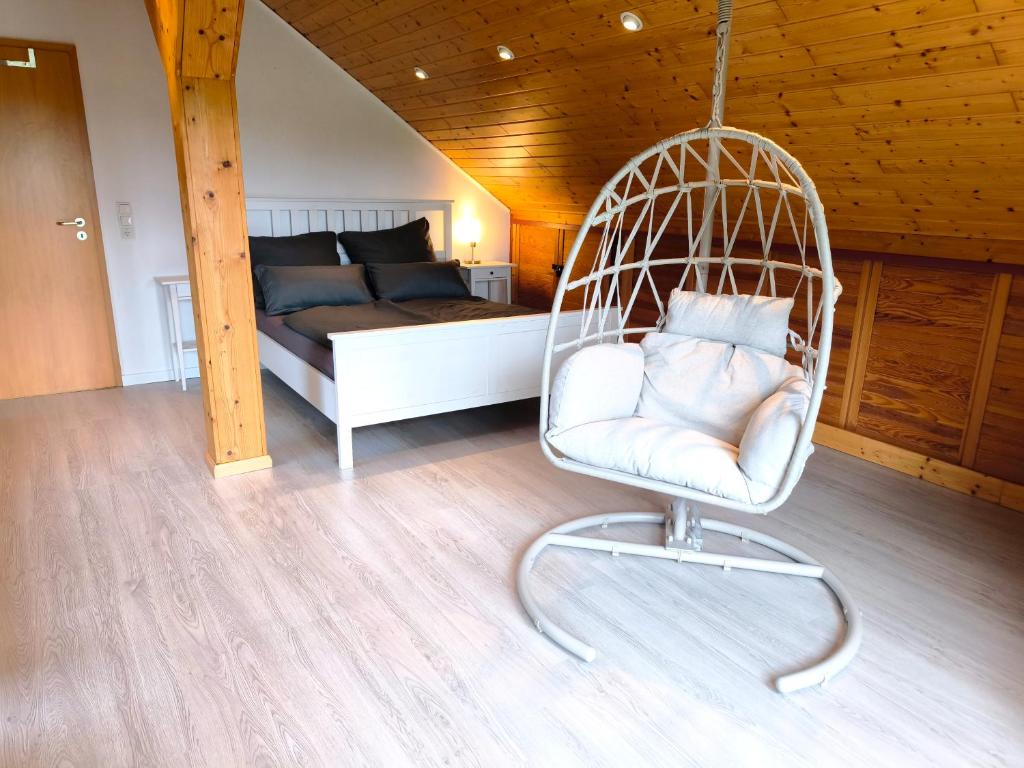 a swinging chair in a room with a bed at Ferienwohnung am Soonwald in Ellern
