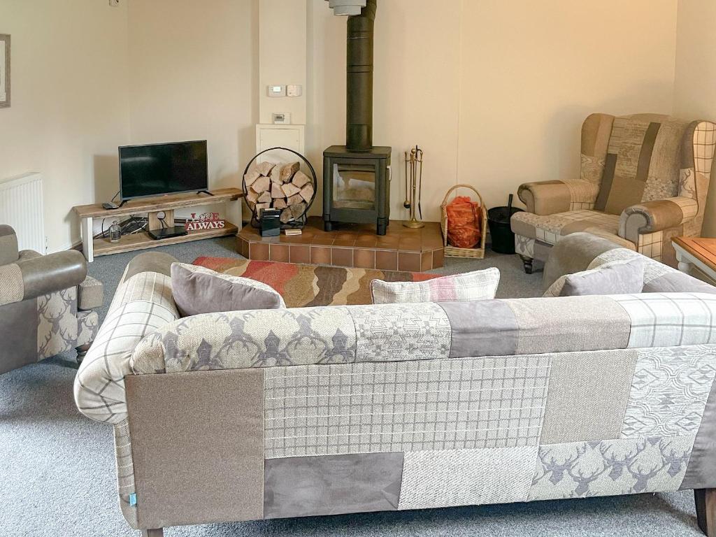 a living room with a couch and a fireplace at The Boyne Arms Cottage in Burwarton