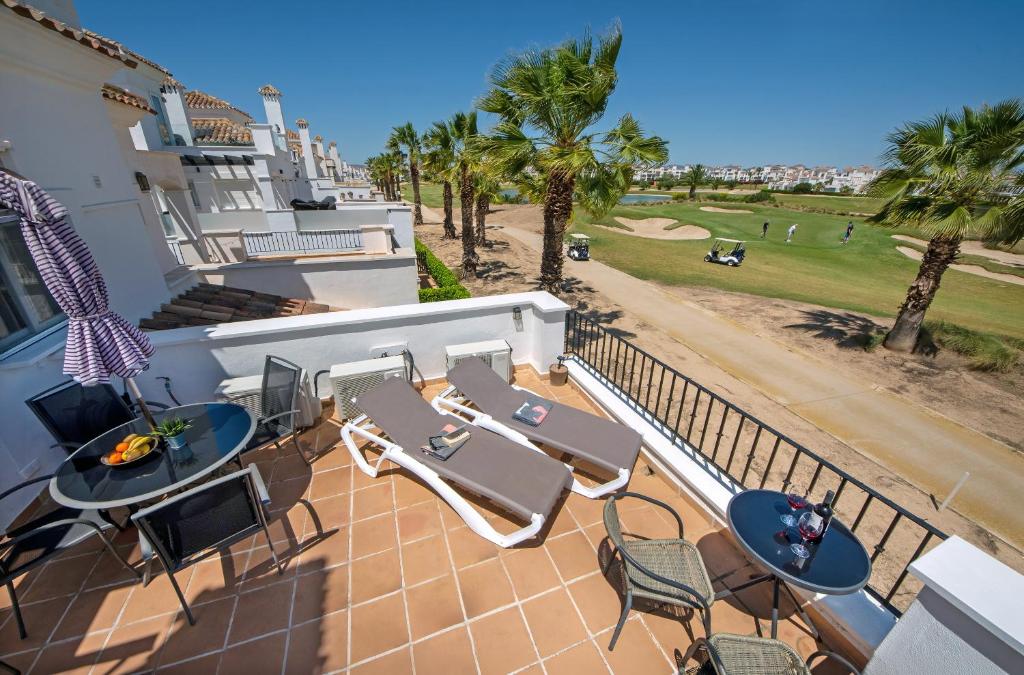 a balcony with tables and chairs and palm trees at Casa La Torre in Roldán