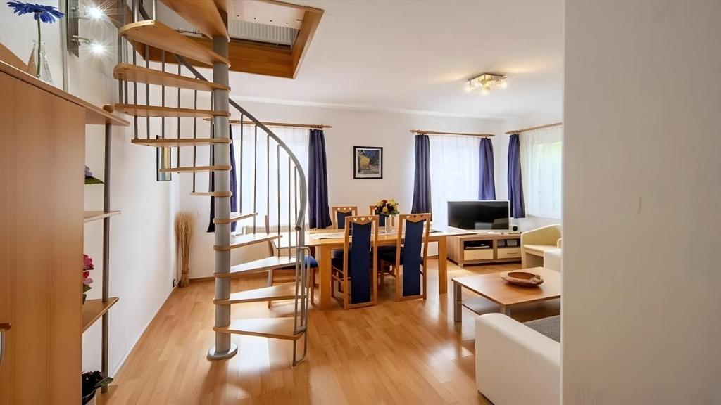 a living room and dining room with a spiral staircase at Ferienwohnung Daun in Daun
