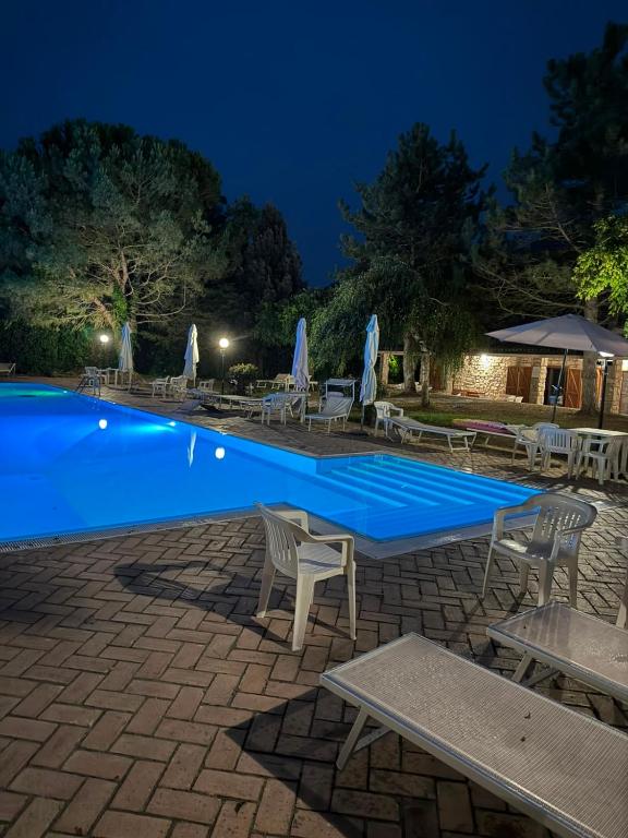 a swimming pool at night with chairs and umbrellas at Il Rifugio nel Matese in San Massimo