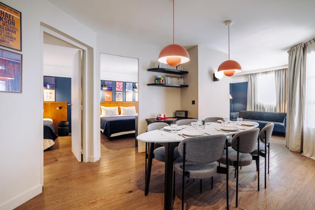 a dining room with a table and chairs and a living room at Appartements RockyPop Grenoble in Grenoble