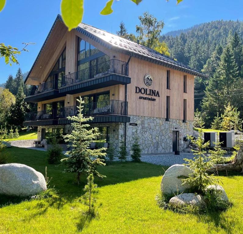 a building with a sign on the side of it at Apartmány Dolina in Belá