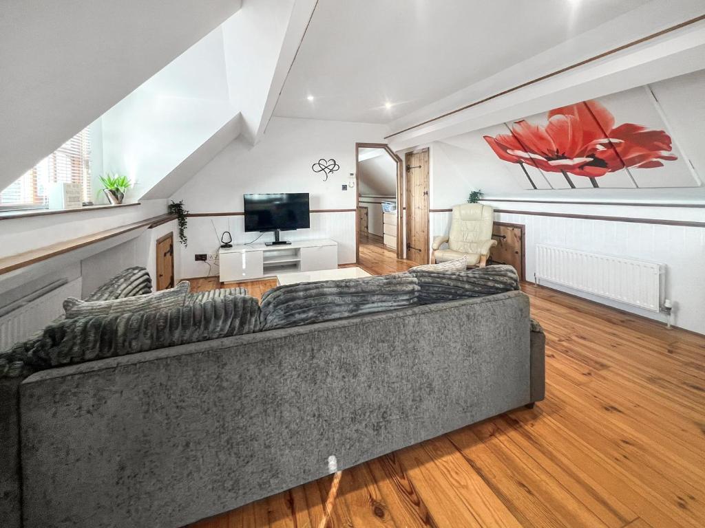 a living room with a couch and a television at The Flat The Farm in Godstone