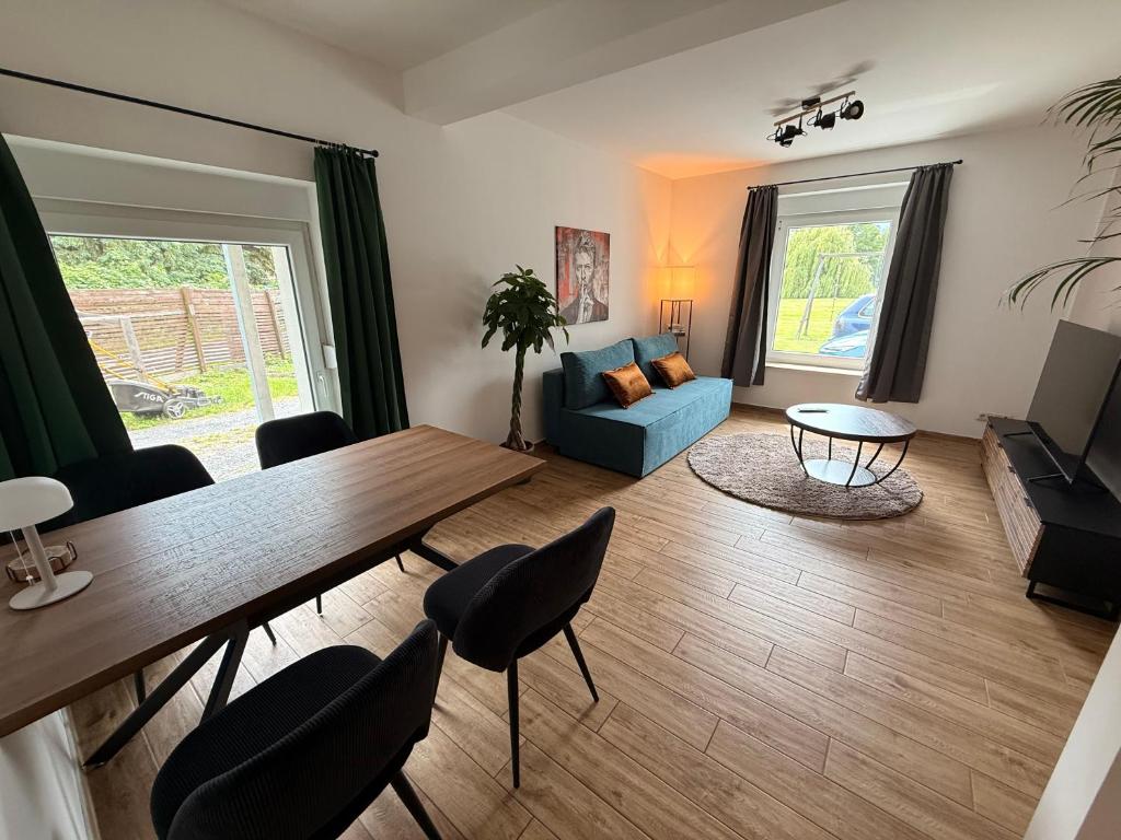 a living room with a table and a blue couch at Gartenwohnung im Kuhstall, Havelzugang, Vollausstattung in Ketzin