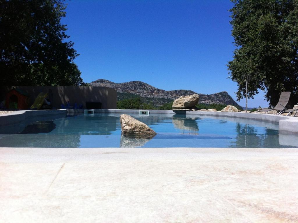 una piscina con rocas en el agua en Domaine Casa Andria, en Barbaggio