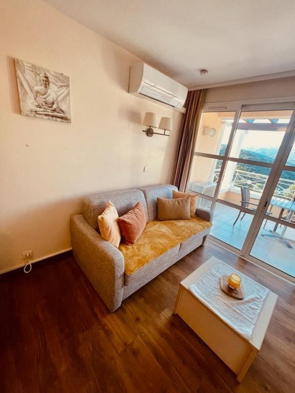 a living room with a couch and a table at Cocon dans le village cap esterel in Saint-Raphaël
