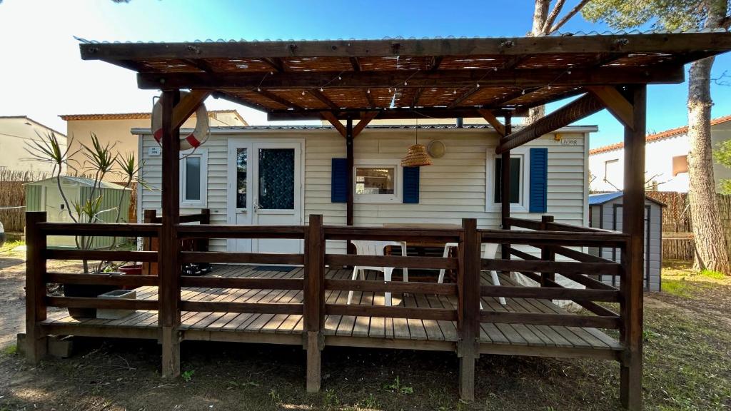 a house with a wooden deck with a pergola at El Moll Grec in L'Escala