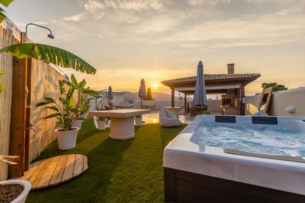 a resort with a hot tub and a table and chairs at Enclave Luxury Apartments in Áyios Kírikos