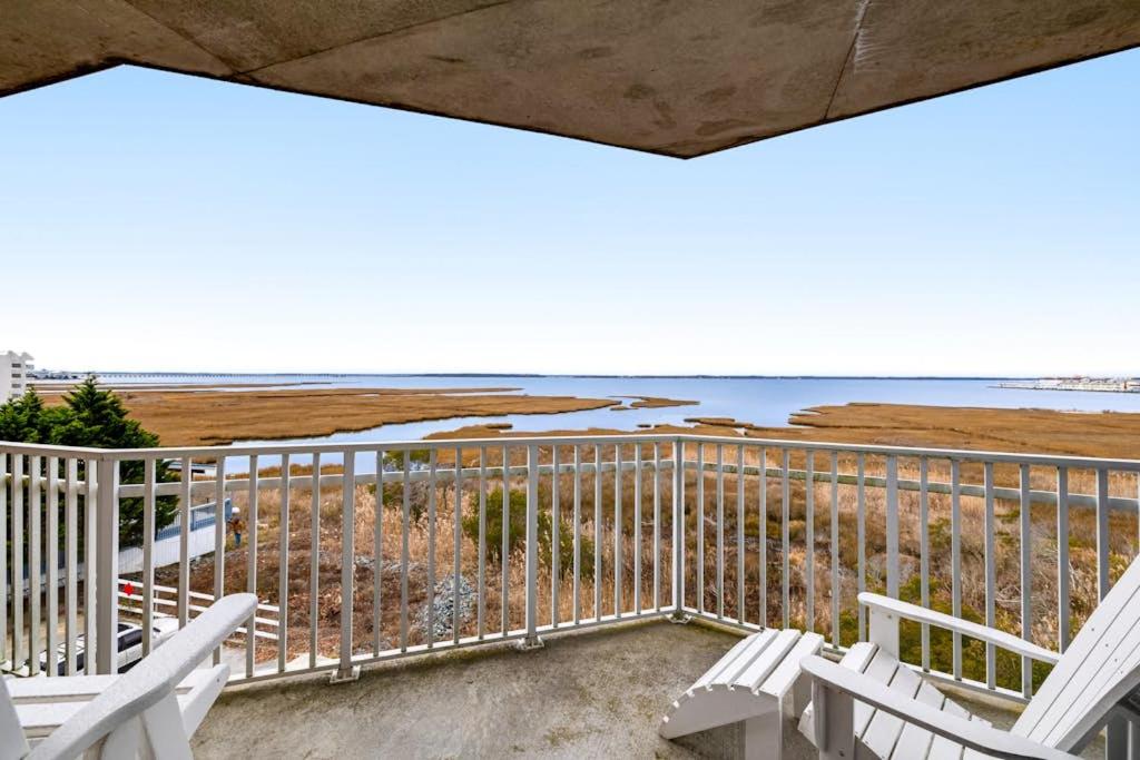 a balcony with white chairs and a view of the ocean at Playa Flamingo #302 in Ocean City
