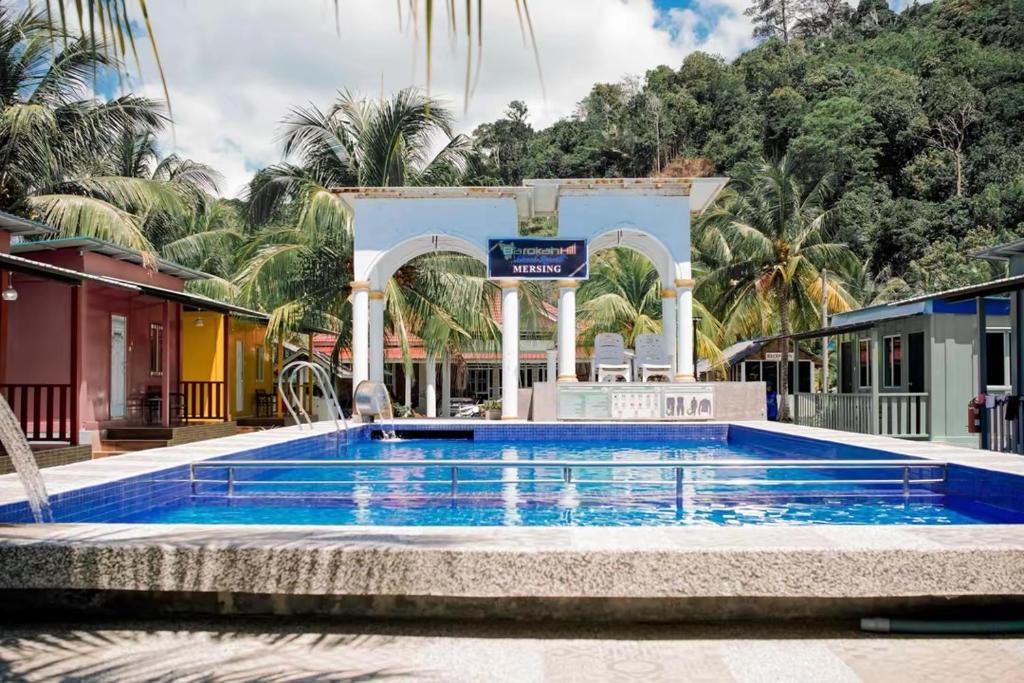 a large swimming pool in a resort with a fountain at Mersing Barokahhill Beach Resort in Kampong Tanjong Resang