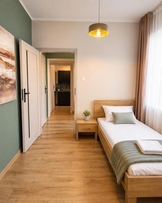 a bedroom with a large bed and a hallway at Apartament Contra II in Wodzisław Śląski