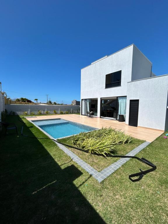 a house with a swimming pool in the yard at Condomínio Bosque da Praia, casa 193 Jacumã RN in Jacumã