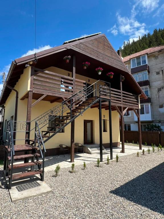 a building with a staircase on the side of it at Casa de sub Hășmaș in Bălan
