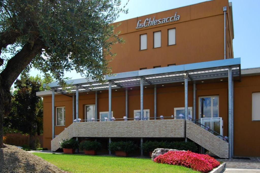 a building with chairs on the front of it at Hotel La Chiesaccia in Crespellano